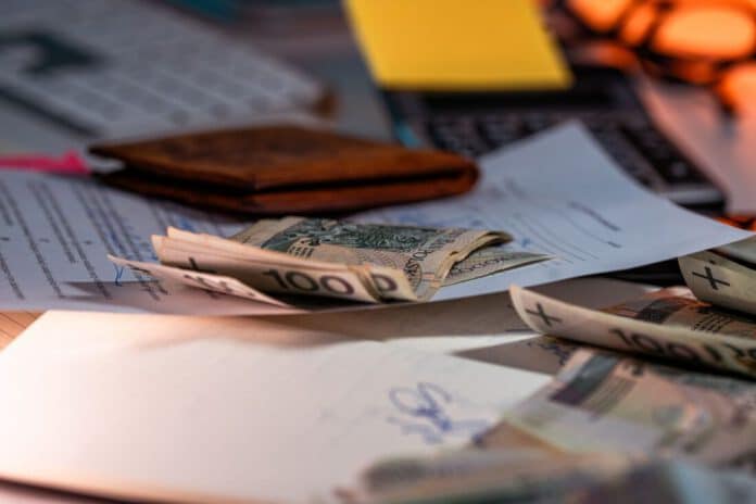 Empleado revisando gastos de viaje en un portátil con billetes y recibos sobre la mesa