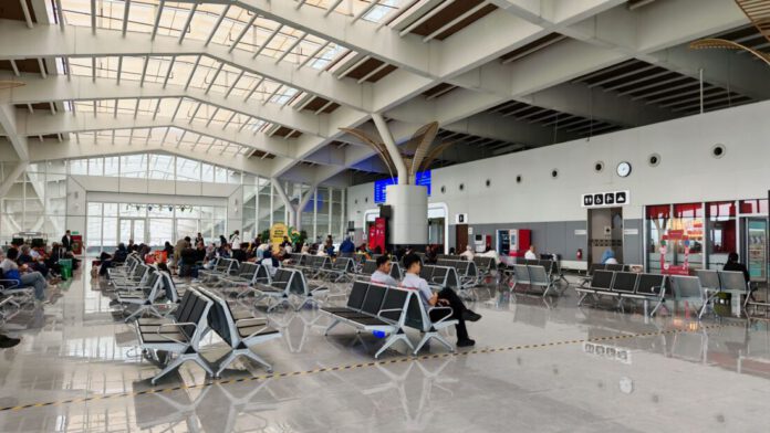 Terminal del aeropuerto de Srinagar con pasajeros y señalética digital