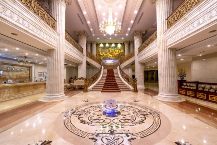 Vestíbulo de hotel de lujo con recepción y huéspedes